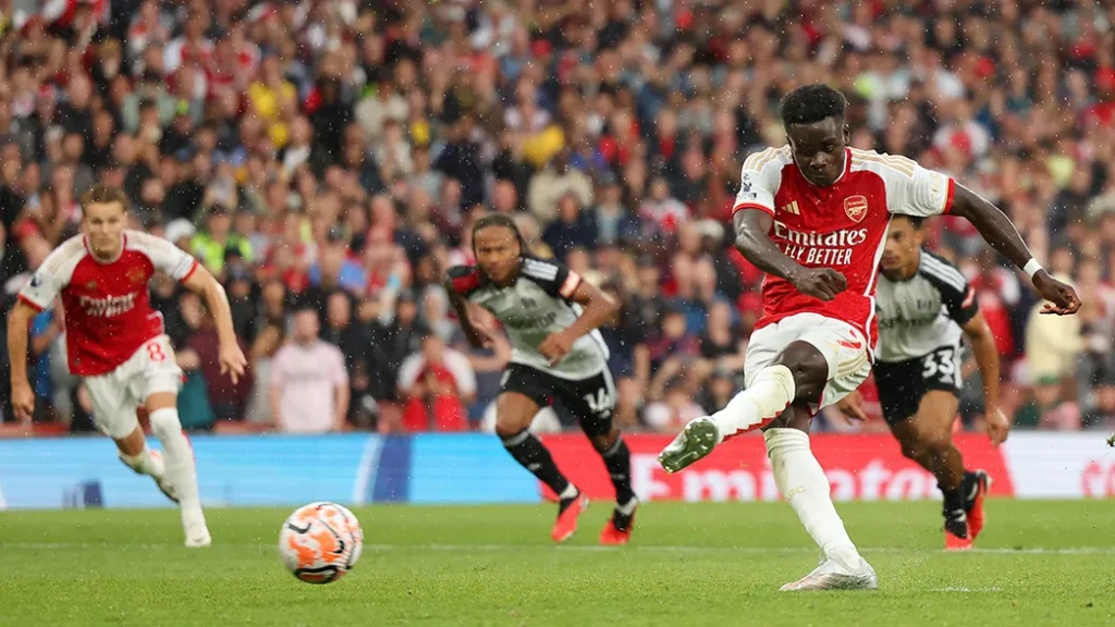 Arsenal player taking a shot at goal.