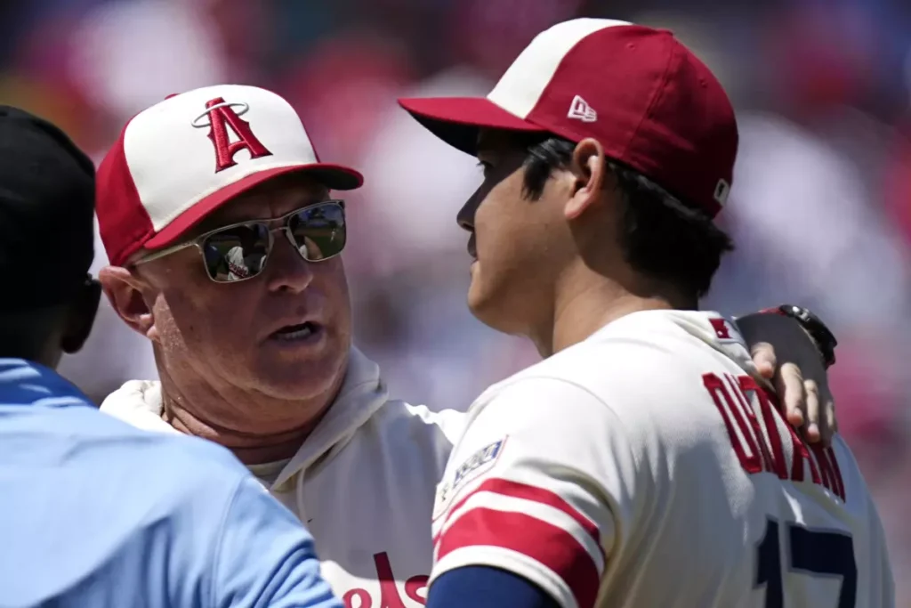 Phil Nevin, Angels' manager, consults Shohei Ohtani prior to his removal from the game due to arm weariness.