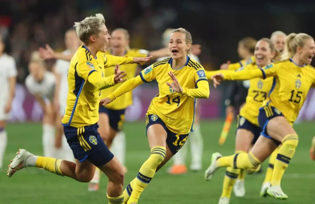 Triumphant Swedish footballers rejoicing post-match victory.